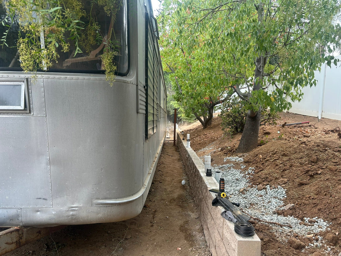 CMU block sand colored retaining wall next to an aluminum trailer ADU
